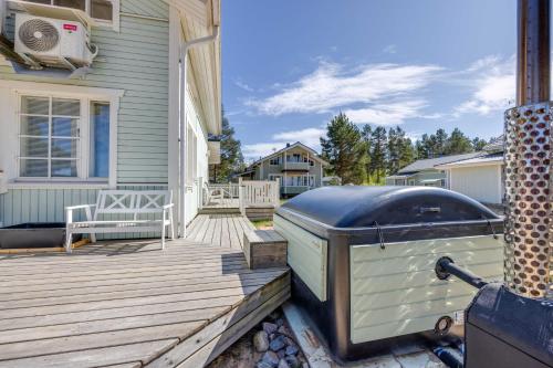 a house with a deck with a grill on it at Beach House Rantadyyni 32 in Kalajoki