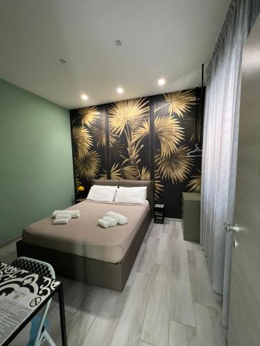 1 dormitorio con 1 cama y una pared con un mural en i Giardini di Rita- Rooms & Garden Loft, en Margherita di Savoia