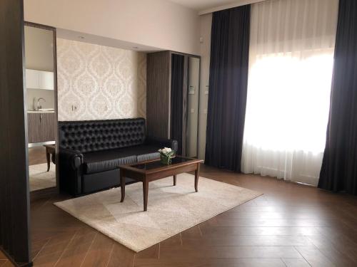 a living room with a black couch and a table at Luxury Villa with Private Pool and Jacuzzi in Mostar