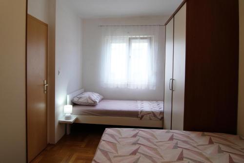 Habitación pequeña con cama y ventana en Apartman Nane, en Kaštela