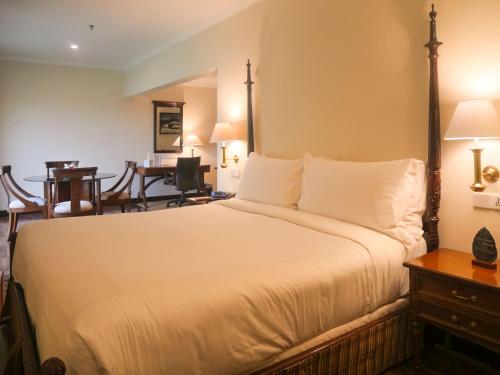 una camera con un grande letto e una scrivania di Karachi Marriott Hotel a Karachi