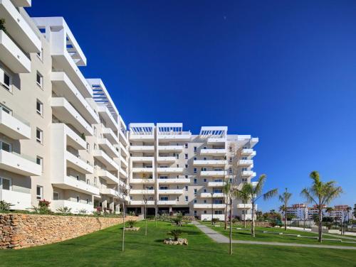 un gran edificio blanco con palmeras delante en Happy holidays en Marbella