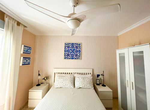 sypialnia z łóżkiem i wentylatorem sufitowym w obiekcie Como en casa w Maladze
