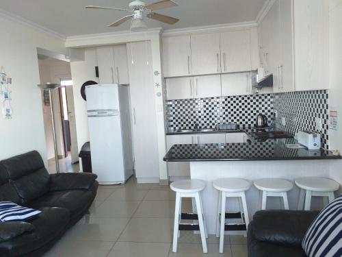 a kitchen and living room with a couch and a counter at Afsaal Holiday Flats in Amanzimtoti