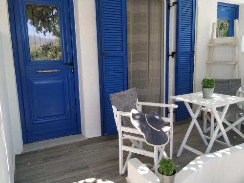 een blauwe deur en een tafel en stoelen op een veranda bij Avlomonasbeach in Livadion