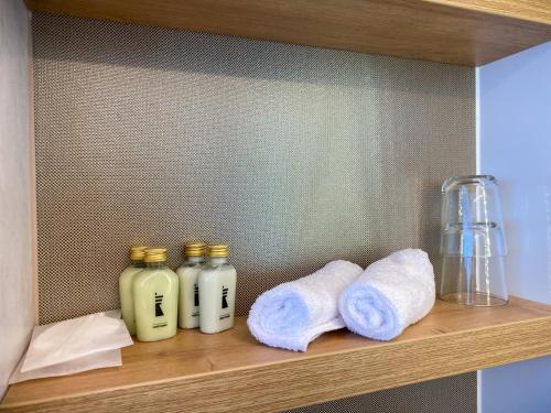 a wooden shelf with towels and bottles on it at Hausboote am Lankenauer Höft in Bremen