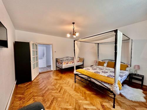 1 dormitorio con cama con dosel y suelo de madera en Anton Pann House - Entire house below the citadel en Sighişoara
