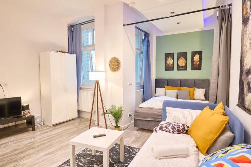 Blue Chili Apartments Prenzlauer Berg في برلين: غرفة معيشة مع أريكة زرقاء وسرير