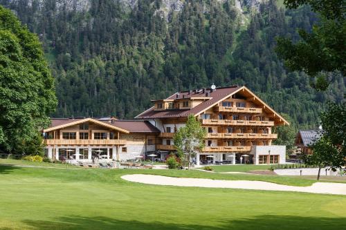 ein großes Resort mit einem Golfplatz und einem Gebäude in der Unterkunft NOVA Moments Boutique Hotel in Pertisau