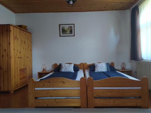 1 dormitorio con 1 cama con sábanas azules y muebles de madera en Frutta Villa, en Cserszegtomaj