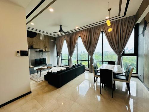 una sala da pranzo e un soggiorno con tavolo e sedie. di Millennium Suite At Opus Residence a Kuala Lumpur