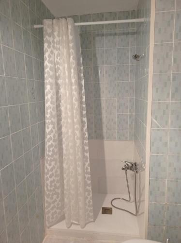 a shower with a white shower curtain in a bathroom at El Olivar in La Adrada