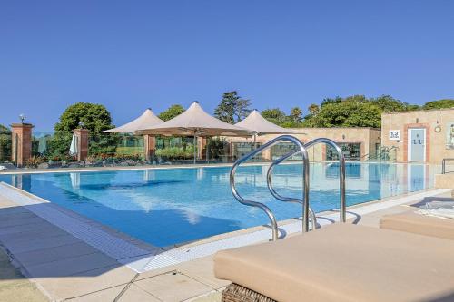 a large swimming pool with chairs and umbrellas at Thurlestone Hotel in Thurlestone