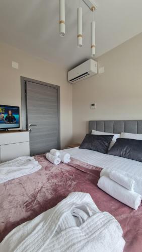 a bedroom with two beds with towels on the floor at Mias luxury spa apartment in Rijeka