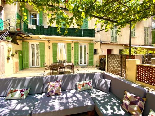 un sofá gris con almohadas en el patio en Appartement terrasse vue lac, en Breil-sur-Roya