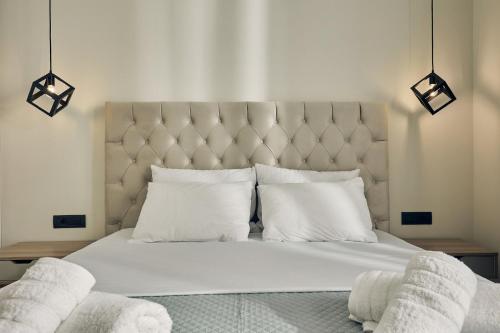 a bedroom with a large white bed with white pillows at Mouzaki's Stone Villas in Volímai