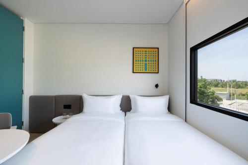 2 camas en una habitación con ventana en GO! Hotel Chonburi at Central Chonburi, en Chonburi