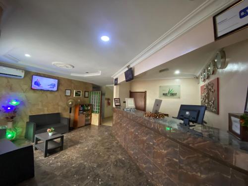 a lobby with a bar in a hotel at Nue-Crest Hotels & Suites in Enugu