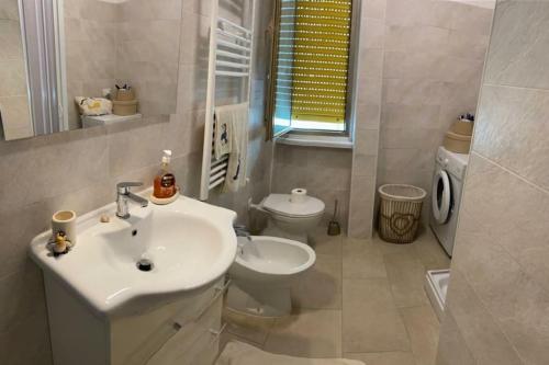 a bathroom with a white sink and a toilet at Appartamento Fronte Mare con ombrellone e sedie sdraio incluse nel costo in Pescara