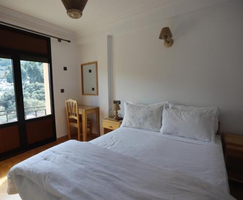 Un dormitorio con una gran cama blanca y una ventana en TAZEKKA PARC HOTEL, en Taza