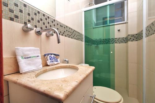 uma casa de banho com um lavatório e uma cabina de duche em vidro. em Rio Spot Homes vista praia D047 no Rio de Janeiro