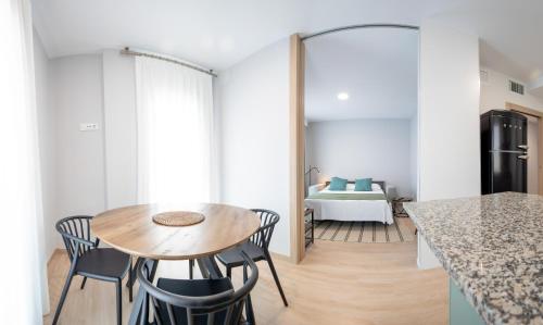 a kitchen and dining room with a table and chairs at Apartamentos Villa Zoila Nigrán in Nigrán