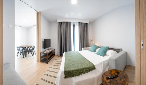 a hotel room with a bed and a table at Apartamentos Villa Zoila Nigrán in Nigrán