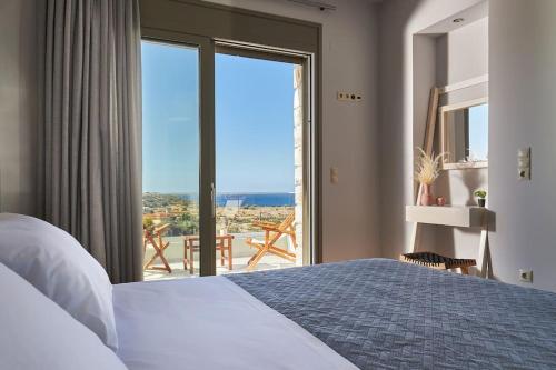 una camera da letto con un letto e una grande finestra di Alba Lilia Cretan Villas a Pitsidia