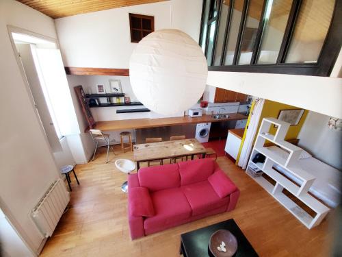 a living room with a pink couch and a table at L'Atelier in La Rochelle