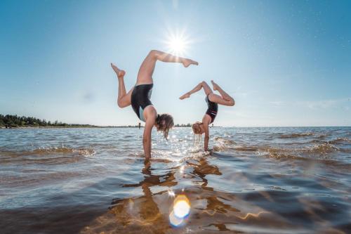 two people jumping into the water in the water at Beach House Rantadyyni 32 in Kalajoki