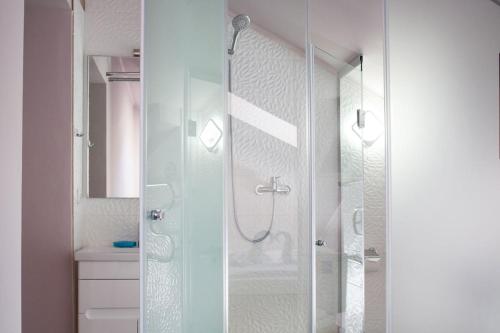 a shower with a glass door in a bathroom at Hotel Skilandhouse in Bukovel
