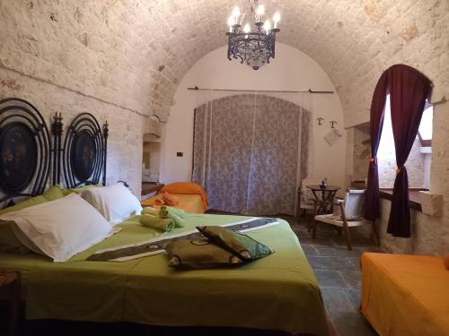 una camera con letto verde e lampadario a braccio di B&B Govinda Shanty House a Gorgofreddo