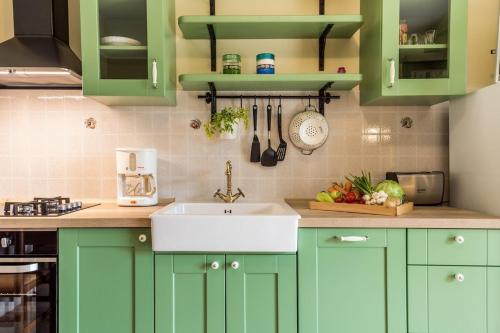 a kitchen with green cabinets and a sink at House Dinka with Pool in Porat