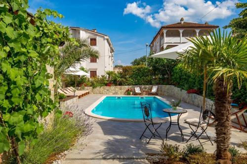 a swimming pool with a table and chairs next to a house at House Dinka with Pool in Porat