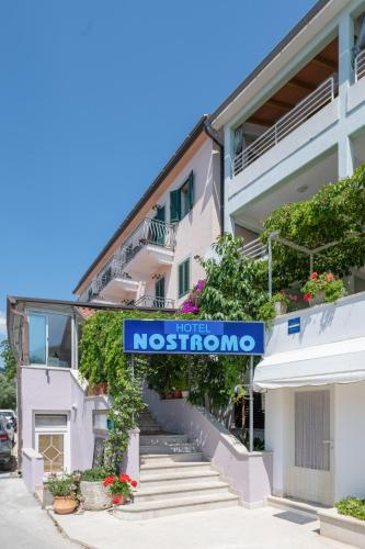 a building with a sign for the museum at Hotel Nostromo in Rabac