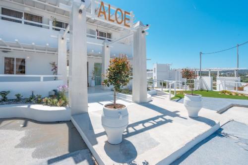 a white building with white columns and a potted plant at Aloe Hotel - Adults Only in Faliraki