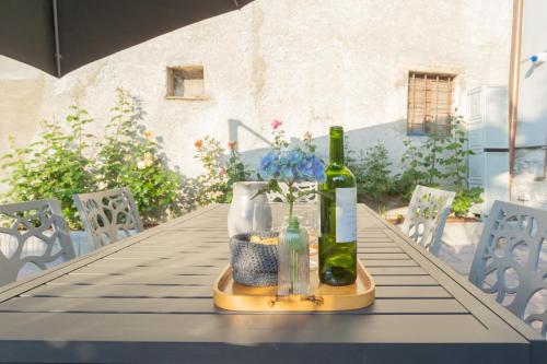 a table with a bottle of wine and flowers on it at Pozzo Vertical Apartment with garden and parking by Rent All Como in Torno