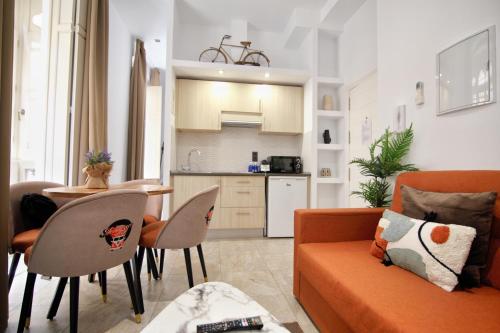 sala de estar con sofá, mesa y cocina en Tennessee Urban Suites, en Málaga