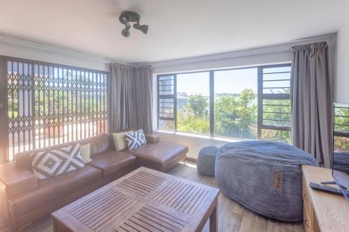 a living room with a couch and a large window at Awesome Views & Beach Proximity in Cape St Francis