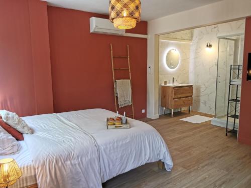 une chambre avec un lit et une salle de bain avec un lavabo dans l'établissement Studio confort - clim - ascenseur, à Cavaillon