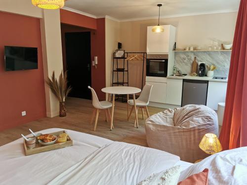 um quarto com uma cama, uma mesa e uma cozinha em Studio confort - clim - ascenseur em Cavaillon