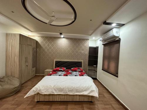 Un dormitorio con una cama con almohadas rojas. en SunRays - Unique 3BHK in the Heart of the City, en Gwalior