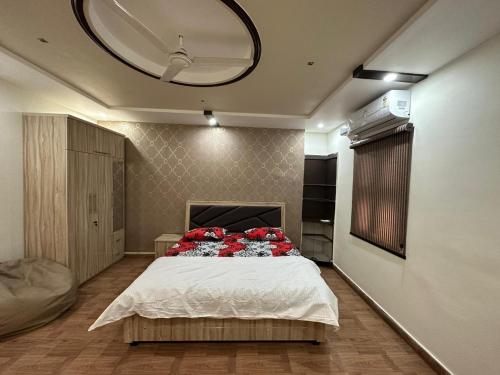 a bedroom with a bed with red pillows on it at SunRays - Unique 3BHK in the Heart of the City in Gwalior