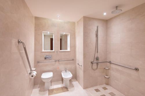 JW Marriott Marquis City Center Doha في الدوحة: حمام مع مرحاض ومغسلة