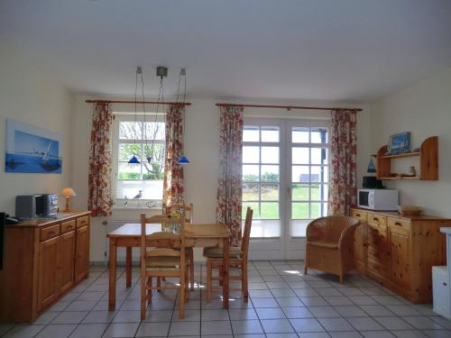 een keuken met een tafel en stoelen en een raam bij Parkstrasse -Whg1 in Wyk auf Föhr