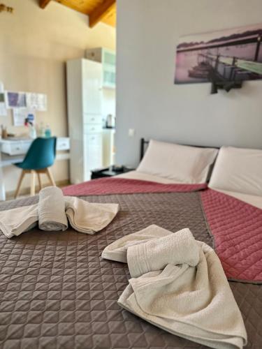 two beds with towels on the floor in a bedroom at Thanos Studio in Artemida
