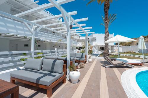 a patio with lounge chairs and a swimming pool at Aloe Hotel - Adults Only in Faliraki