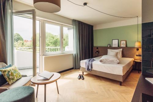 ベルリンにあるharry's home hotel & apartmentsのベッドルーム1室(ベッド1台、テーブル、椅子付)