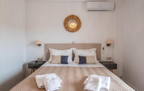 een slaapkamer met een groot bed met 2 nachtkastjes bij Epithea Suites Kythnos 3 με ιδιωτική πισίνα in Kithnos