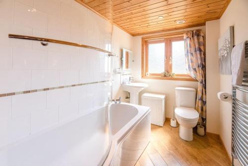 a bathroom with a tub and a toilet and a sink at Mallards' Rest, Fritton in Fritton Norfolk
